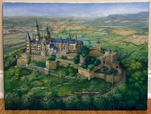 An aerial view of Hohenzollern Castle in Germany, a large sprawling castle set atop a hill and surrounded by forest, with villages seen in the distance behind it